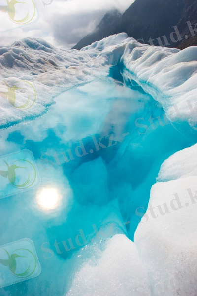 Ярко-синее озеро, окруженное белым льдом на темной горе